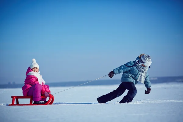 Boy pulling sledge with sister — Stock Photo, Image