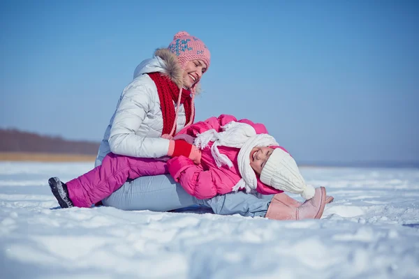 Mujer jugando con su hija en invierno —  Fotos de Stock