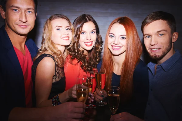 Amigos brindam com champanhe na festa — Fotografia de Stock