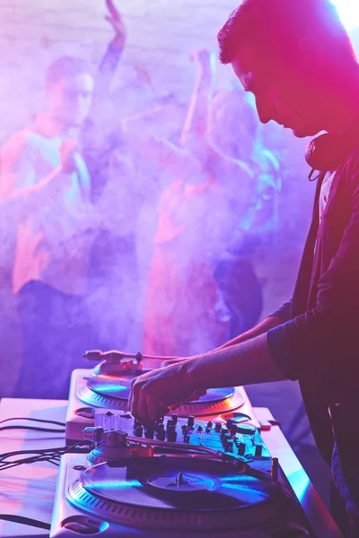 Young deejay adjusting sound — Stock Photo, Image