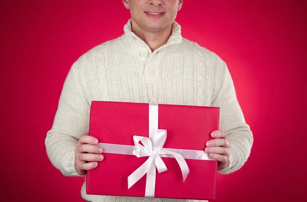 Man in white pullover holding gift — Stock Photo, Image