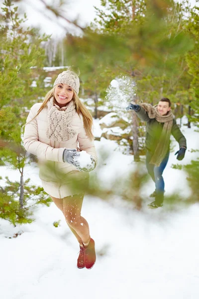 Casal jogando bolas de neve no parque — Fotografia de Stock