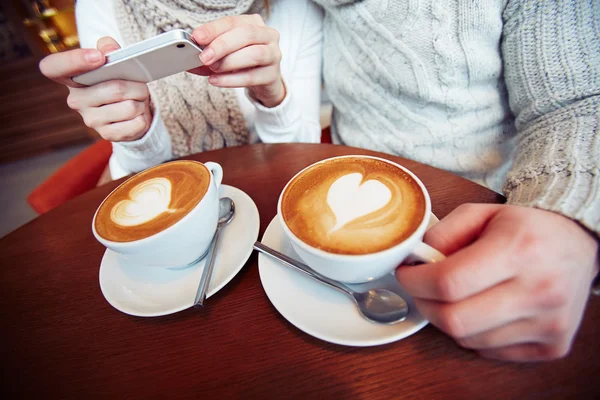 Casal tirando foto de cappuccino — Fotografia de Stock