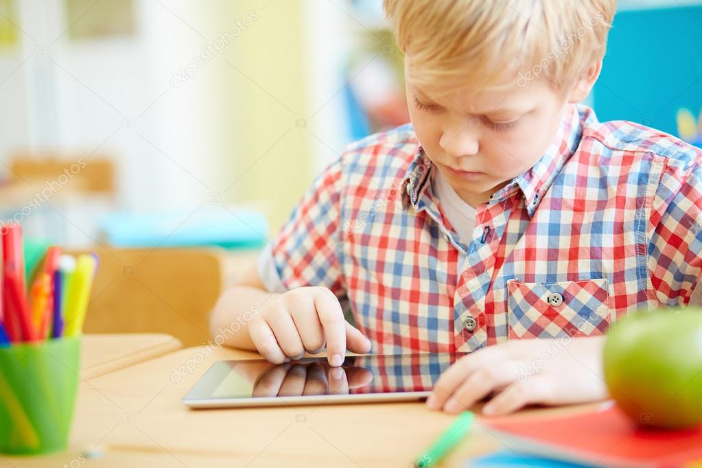 Schoolboy with touchpad at lesson