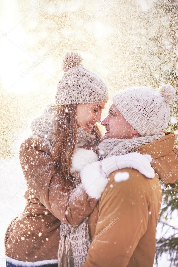 Couple standing in snowfall