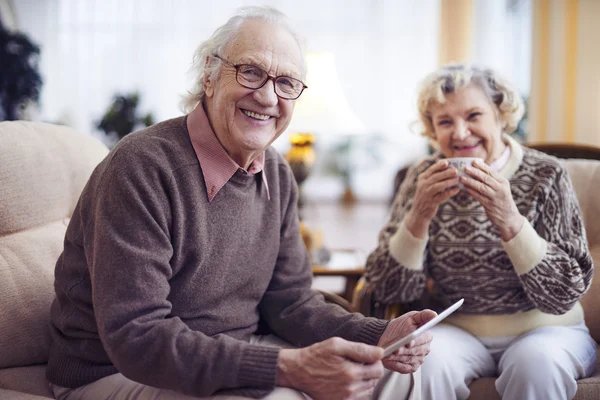 Senior man met vrouw houdt van tablet pc — Stockfoto