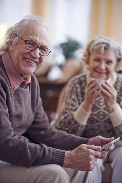 Senior man met vrouw houdt van tablet pc — Stockfoto