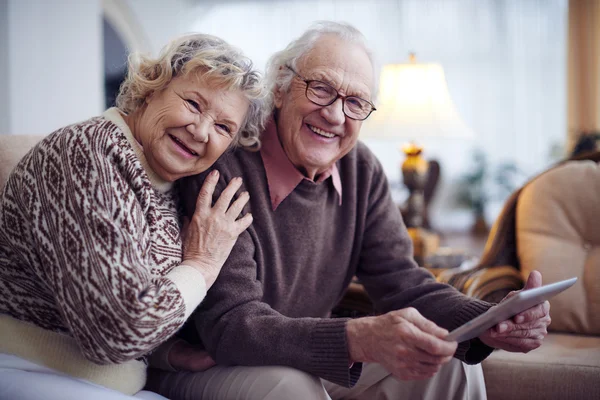 Oudere man en vrouw met behulp van de touchpad — Stockfoto