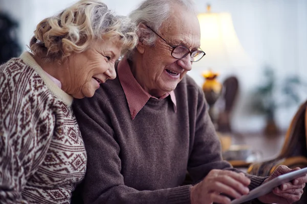 Oudere man en vrouw met behulp van de touchpad — Stockfoto