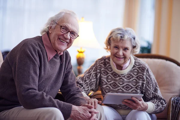 Oudere man en vrouw met behulp van de touchpad — Stockfoto