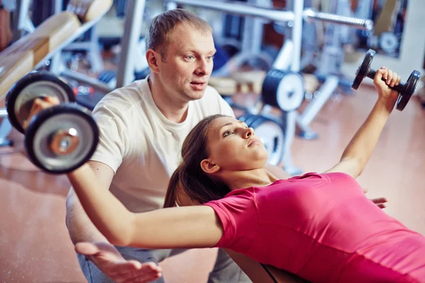 Meisje training in de fitnessruimte met trainer — Stockfoto