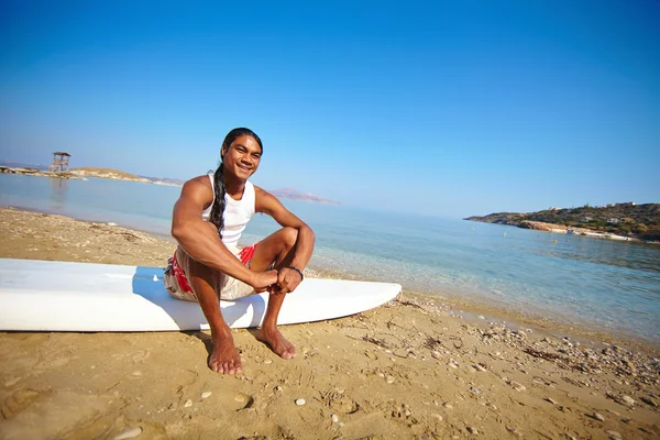男子坐在冲浪板上 — 图库照片