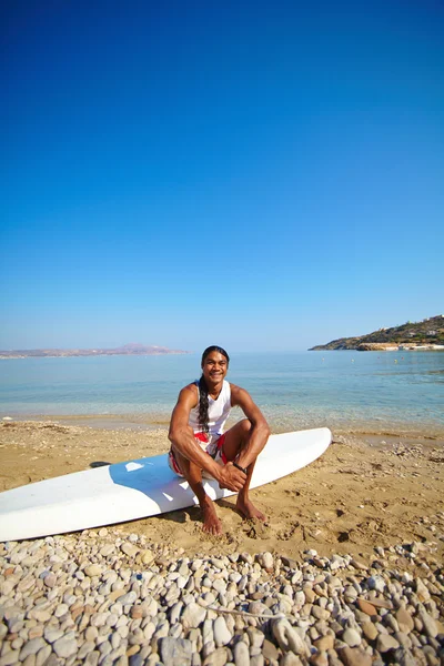 Man sitter i surfing styrelsen — Stockfoto