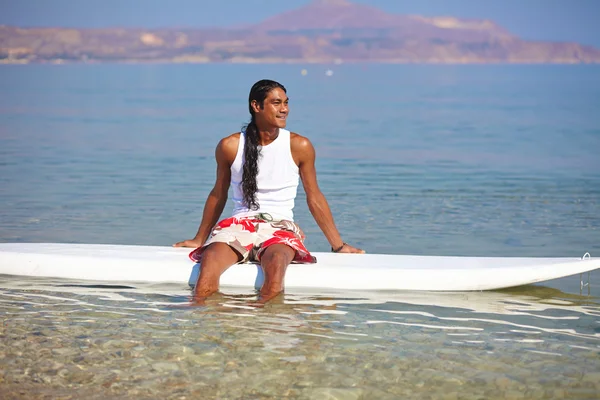 Hombre sentado en la tabla de surf — Foto de Stock