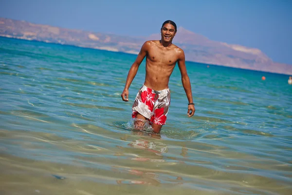 Un hombre sin camisa parado en el agua — Foto de Stock