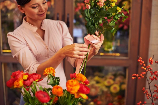 Floristería femenina atando rosas — Foto de Stock