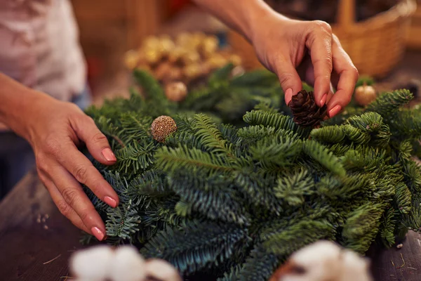 Női kezek díszítő tűlevelű koszorú — Stock Fotó