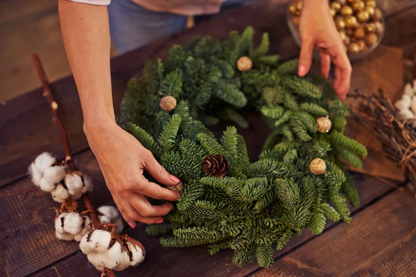 Női kezek díszítő tűlevelű koszorú — Stock Fotó