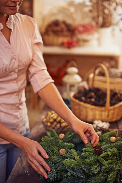 Mujer decorando corona de coníferas — Foto de Stock