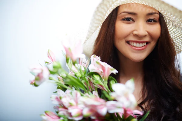 Frau mit Hut und Blumen — Stockfoto