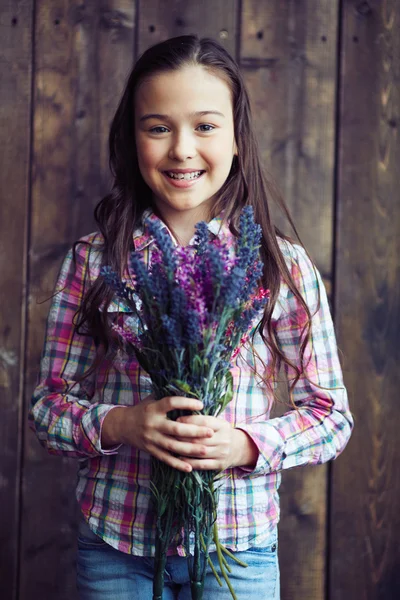 Маленька дівчинка тримає дикі квіти — стокове фото