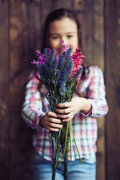 Menina segurando flores silvestres — Fotografia de Stock