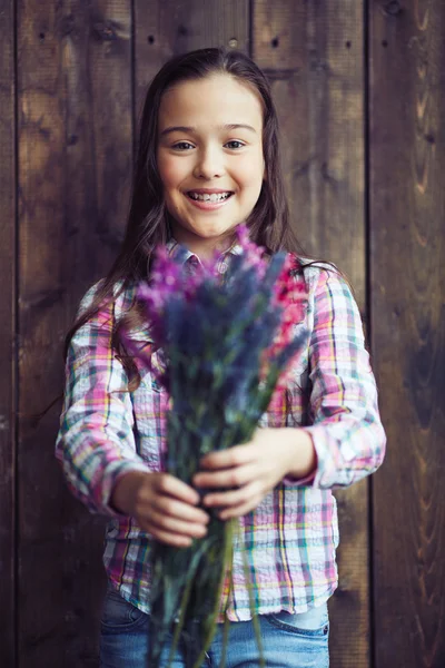 Маленька дівчинка тримає дикі квіти — стокове фото