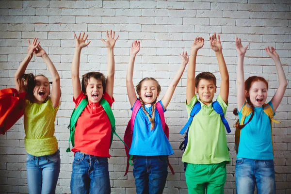 Ekstatische Schüler mit Rucksäcken — Stockfoto