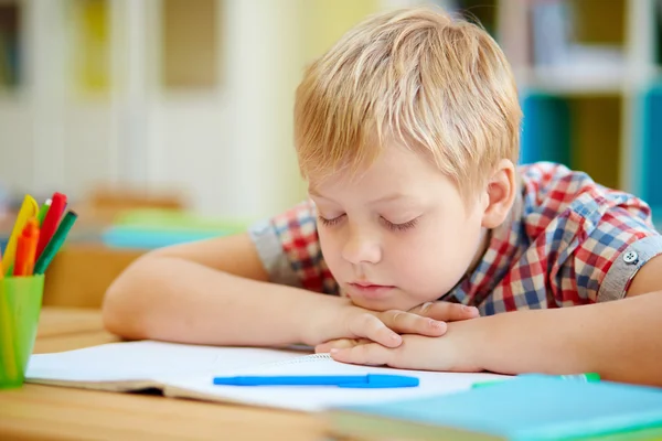 Boy napping by desk Royalty Free Stock Photos