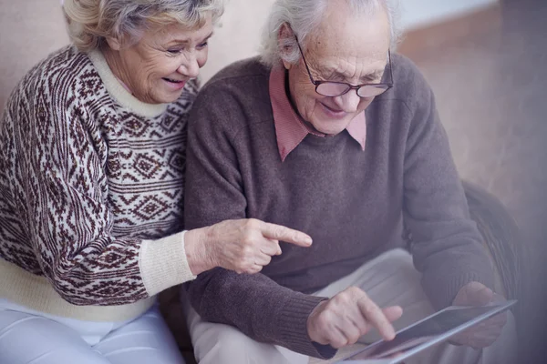 Pensionnés pointant vers l'écran tactile — Photo