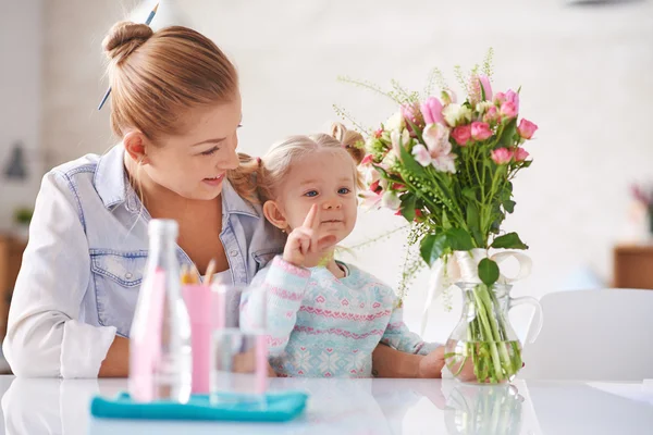 Mère montrant des fleurs à sa fille — Photo