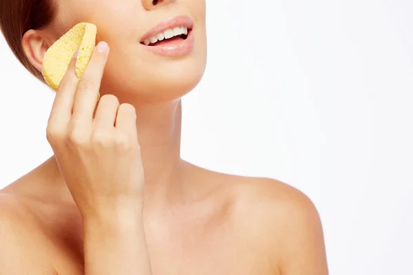 Woman cleaning face with sponge — Stock Photo, Image