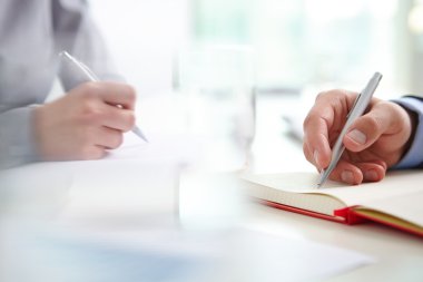 Defterlere yazı yazan eller