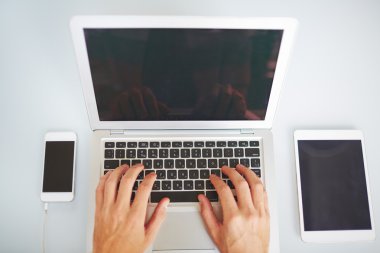 Eller dizüstü bilgisayarda yazıyor.