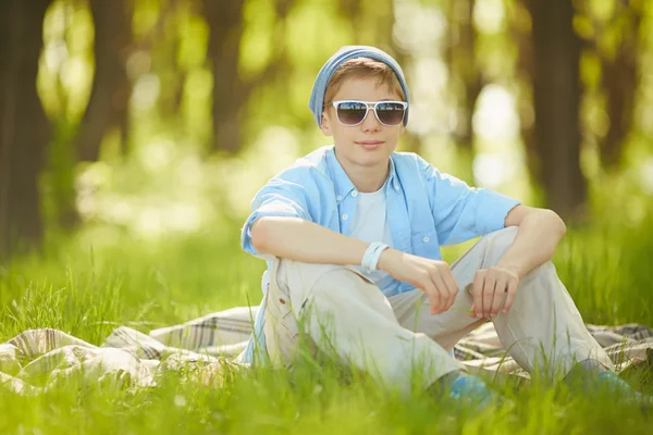 Junge sitzt auf Gras — Stockfoto