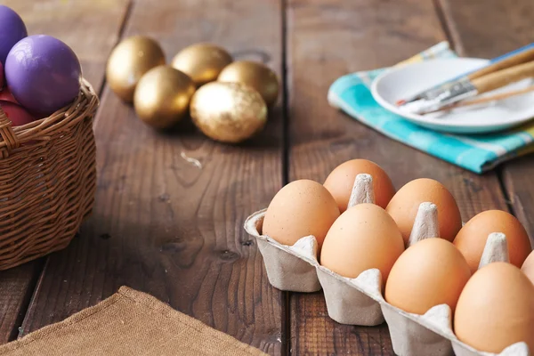 Ovos em recipiente com ferramentas para pintura — Fotografia de Stock
