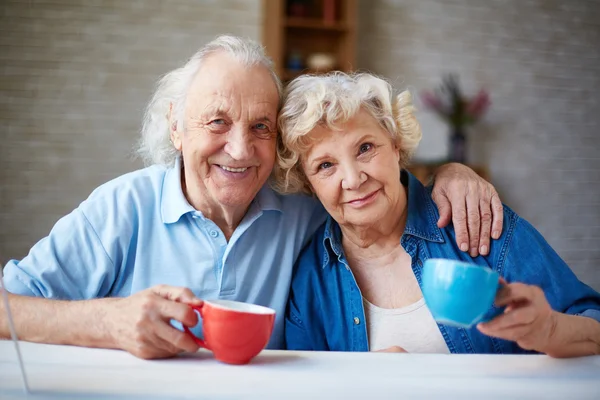 Ласковые пожилые люди с чашками — стоковое фото
