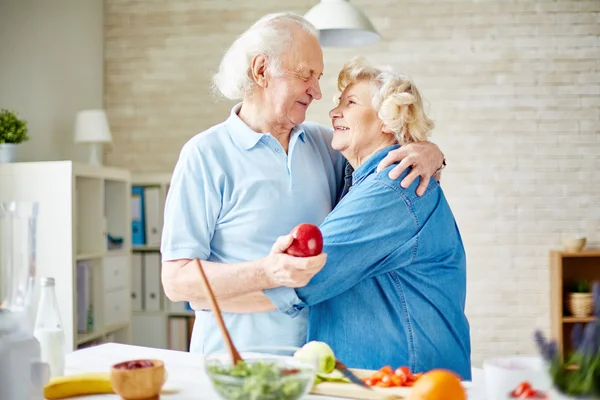 Anziani che abbracciano in cucina — Foto Stock