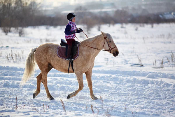 Kleines Mädchen reitet Pferd — Stockfoto