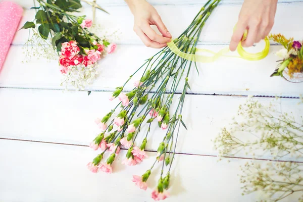 Manos femeninas atando flores frescas — Foto de Stock