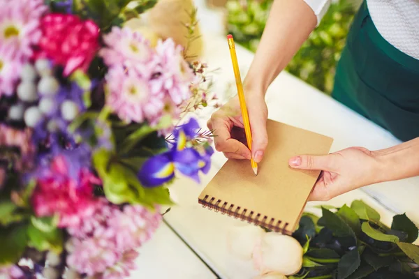 Fiorista con matita prendere appunti — Foto Stock