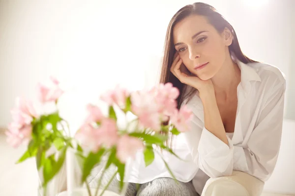 Mujer mirando ramo de lirios rosados — Foto de Stock