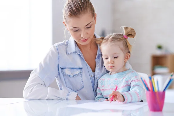 Little girl drawing with mother — Stock Photo, Image