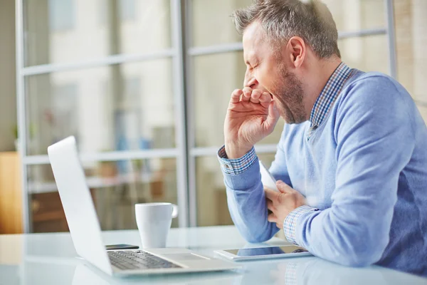 Homme bâillant sur le lieu de travail — Photo