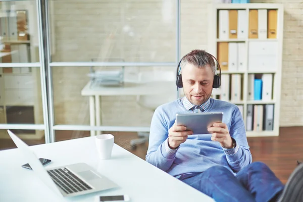 Businessman relaxing by workplace — Stock Photo, Image