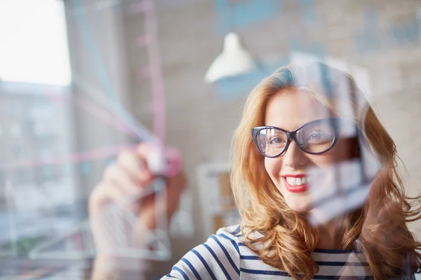 Frau zeichnet auf Glas — Stockfoto