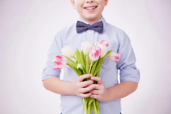 Pojke anläggning tulpaner — Stock fotografie