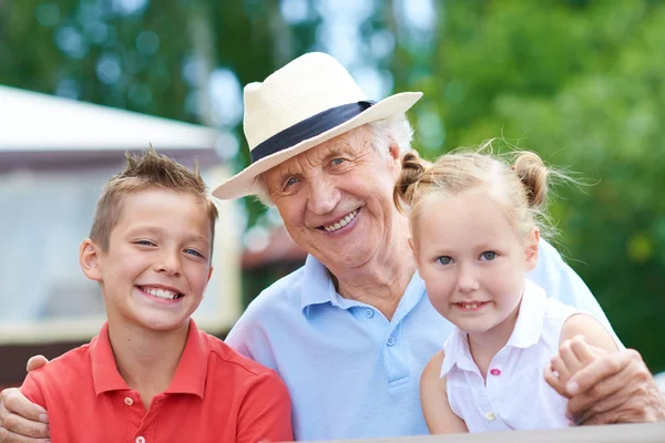 Старший мужчина с внуками — стоковое фото