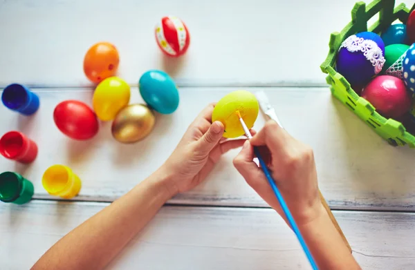 Детские руки рисуют пасхальное яйцо — стоковое фото