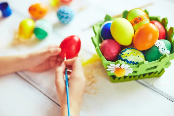 Barnet händer målning röda påskägg — Stockfoto